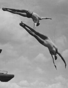 Two people diving into water.