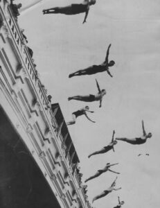 Many people diving into water.